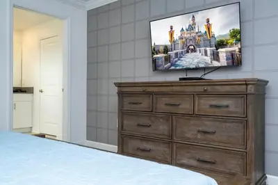 a bedroom with a dresser and a flat screen tv at Gorgeous 4Bd with Pool at Storey Lake Resort 4475 in Kissimmee