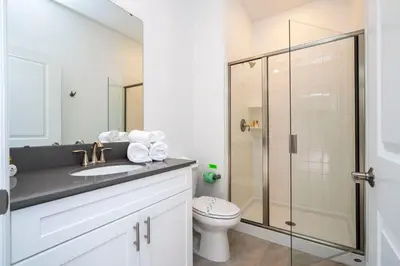 a bathroom with a toilet and a glass shower at Gorgeous 4Bd with Pool at Storey Lake Resort 4475 in Kissimmee