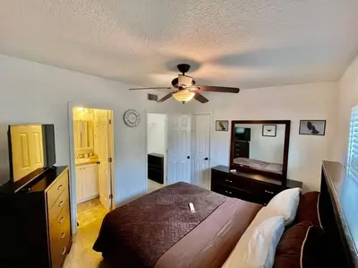 a bedroom with a bed and a ceiling fan at Cozy Modest Home near Universal Studios/VolcanoBay in Orlando