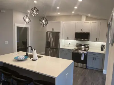 a kitchen with white cabinets and a large island in it at Clear Lake Retreat: Private pool, lakefront in Orlando