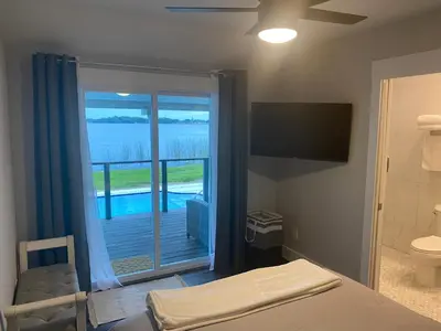 a bedroom with a bed and a view of a pool at Clear Lake Retreat: Private pool, lakefront in Orlando