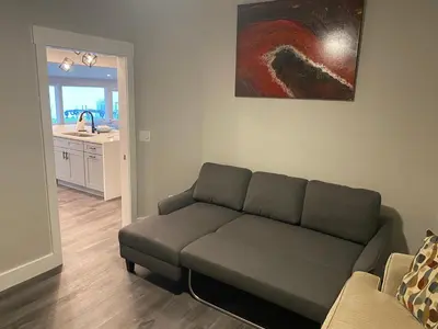 a living room with a couch and a painting on the wall at Clear Lake Retreat: Private pool, lakefront in Orlando
