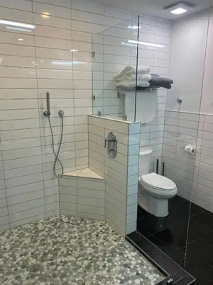 a bathroom with a toilet and a glass shower at Clear Lake Retreat: Private pool, lakefront in Orlando