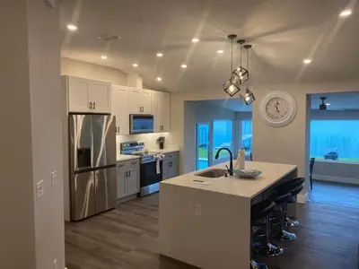 a kitchen with white cabinets and a sink and a counter at Clear Lake Retreat: Private pool, lakefront in Orlando