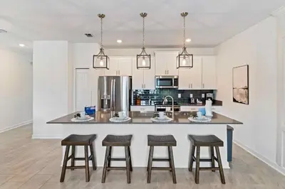 a kitchen with a large island with bar stools at 4423 Scene Lane in Kissimmee