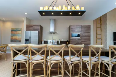 a kitchen with a bar with stools and a dining room at Magical 4suites Home w jacuzzi near Disney 7497 in Orlando