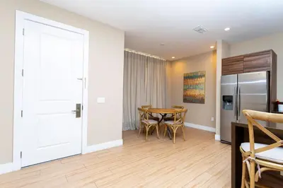 a kitchen and dining room with a table and a refrigerator at Magical 4suites Home w jacuzzi near Disney 7497 in Orlando