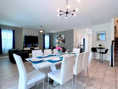 a dining room and living room with a table and chairs at Spacious Home with Fun Decore and Game Room-4544TB in Kissimmee