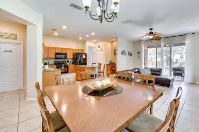a dining room and living room with a table and chairs at 10 Mi to Disney Home with Game Room and Lanai! in Kissimmee