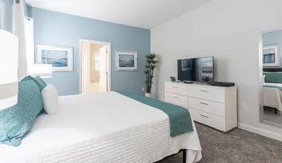 a bedroom with a white bed and a television at 820DSD - The Retreat at ChampionsGate home in Orlando