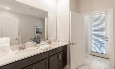 a white bathroom with a sink and a mirror at 820DSD - The Retreat at ChampionsGate home in Orlando