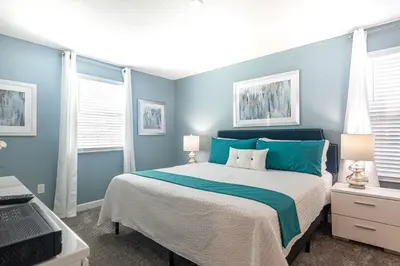 a bedroom with a large bed with blue walls at 820DSD - The Retreat at ChampionsGate home in Orlando