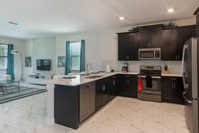 a large kitchen with brown cabinets and appliances at 820DSD - The Retreat at ChampionsGate home in Orlando