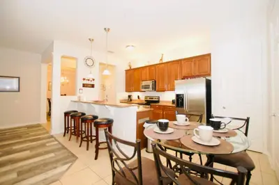 a kitchen with a table and some chairs and a counter at Vista Cay Luxury Loft in Orlando