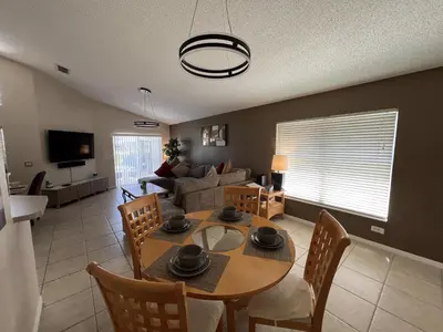 a living room with a table and a couch at Emerald Escape - New Pool Home in Kissimmee