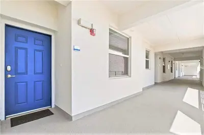 an empty hallway with a blue door in a building at Cozy Condo Only 6 Minutes From Disney World in Kissimmee
