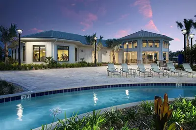 a house with a swimming pool in front of a house at Cozy Condo Only 6 Minutes From Disney World in Kissimmee