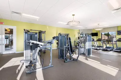 a gym with several tread machines in a room at Cozy Condo Only 6 Minutes From Disney World in Kissimmee