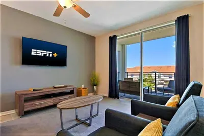 a living room with a couch and a tv at Cozy Condo Only 6 Minutes From Disney World in Kissimmee