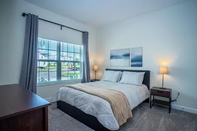 a bedroom with a bed and a large window at Relax in Ultimate Comfort with Pool & BBQ Area in Kissimmee