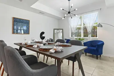 a dining room with a wooden table and chairs at Exquisite First-Floor Condo, 7 Min to Disney in Kissimmee