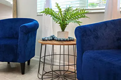 a plant in a vase on a table next to two chairs at Exquisite First-Floor Condo, 7 Min to Disney in Kissimmee