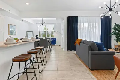 a kitchen and living room with a couch and a bar at Exquisite First-Floor Condo, 7 Min to Disney in Kissimmee