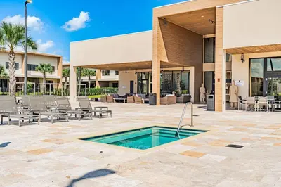 a patio with a swimming pool in front of a building at Sophisticated 4 En Suites w Private Hot Tub & BB in Orlando