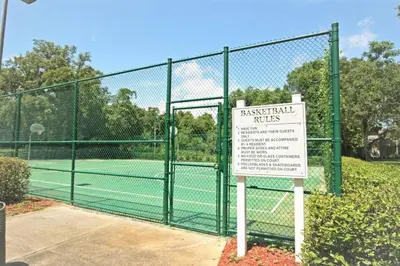 a tennis court with a sign in front of a fence at 2BR2BA Getaway 7 Miles from Orlando Parks in Kissimmee