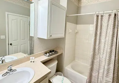 a bathroom with a sink and a toilet and a tub at 2BR2BA Getaway 7 Miles from Orlando Parks in Kissimmee