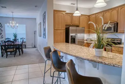 a kitchen and dining room with a counter and chairs at Vista Cay Luxury 3BR Condo in Orlando