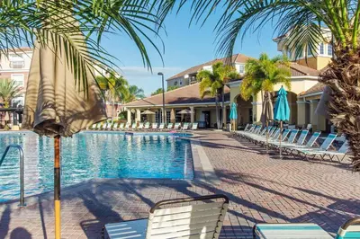 a resort swimming pool with chairs and umbrellas at Vista Cay Luxury 3BR Condo in Orlando