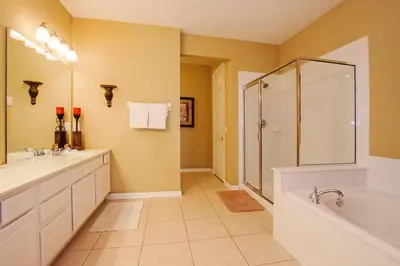 a bathroom with two sinks and a shower and a tub at Luxury Lake View Condo-Vista Cay in Orlando