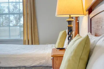 a bedroom with a bed and a lamp on a night stand at Luxury Lake View Condo-Vista Cay in Orlando