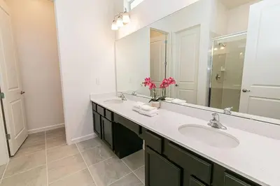 a bathroom with a sink and a mirror at ☀️12BR Disney Villa Paradise w/ Game Room & Pool/Spa☀️ in Kissimmee