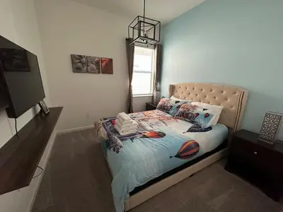 a bedroom with a bed in a room with a tv at ☀️12BR Disney Villa Paradise w/ Game Room & Pool/Spa☀️ in Kissimmee