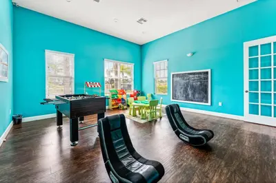 a blue room with a piano and chairs at Modern Family-Friendly Townhome – 10 Min Parks in Kissimmee