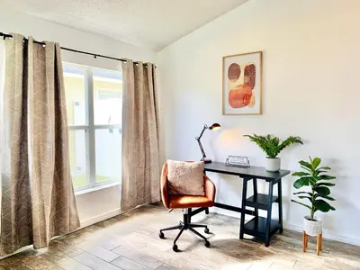 an office with a desk and a chair and a window at Amazing Pool Spacious 3BR House near Disney in Kissimmee