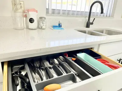 a kitchen drawer filled with utensils next to a sink at Beautiful 3BR House with Private Pool near Disney in Kissimmee
