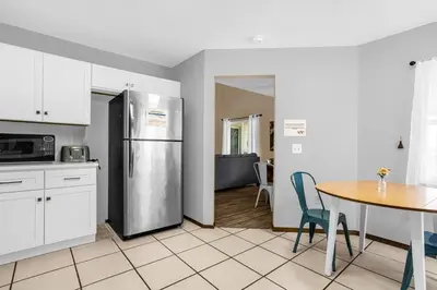 a kitchen with a stainless steel refrigerator and a table at Amazing Blue Private Pool 4BR House Near Disney in Kissimmee