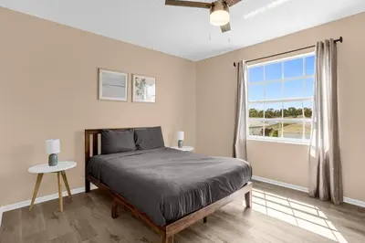 a bedroom with a bed and a window at Amazing Blue Private Pool 4BR House Near Disney in Kissimmee