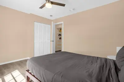 a bedroom with a bed and a ceiling fan at Amazing Blue Private Pool 4BR House Near Disney in Kissimmee