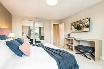 a bedroom with a bed and a desk with a chair at 7992 Cozy 5BD Disney Getaway with Pool in Orlando