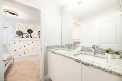 a white bathroom with two sinks and a mirror at 7992 Cozy 5BD Disney Getaway with Pool in Orlando