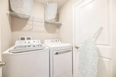 a kitchen with a white stove and a washer and dryer at 7992 Cozy 5BD Disney Getaway with Pool in Orlando