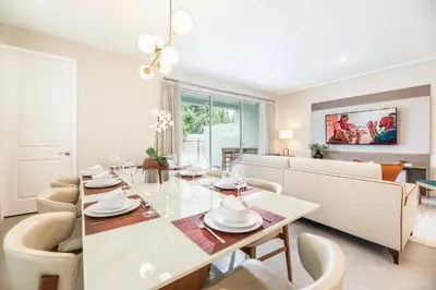 a dining room and living room with a table and chairs at 7992 Cozy 5BD Disney Getaway with Pool in Orlando
