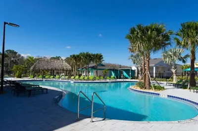 a swimming pool at a resort with palm trees at Splendid 5Bd Close to Disney at Storey Lake 4251 in Kissimmee