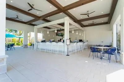 a large room with tables and chairs and a kitchen at Splendid 5Bd Close to Disney at Storey Lake 4251 in Kissimmee