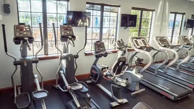 a gym with rows of treadmills and elliptical machines at Near Disney - 5BR Home- Games Pool Hot Tub & BBQ in Kissimmee