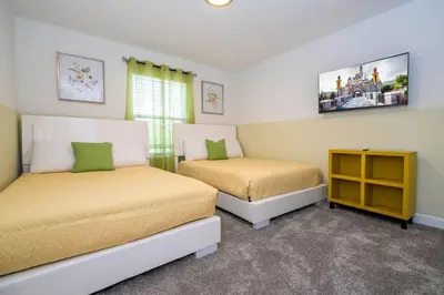 a bedroom with two beds and a tv on the wall at Marvelous 4Bd w Pool Close to Disney at Storey Lake 2629 in Kissimmee